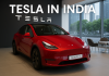 Red Tesla Model Y displayed in a modern Tesla showroom in India with “Tesla in India” signage and large glass windows overlooking an urban skyline.